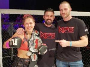 Coaches Ryan Raleigh and Eric Philips with Maryia Arlova after winning the NFC Muay Thai Fly Weight belt. 